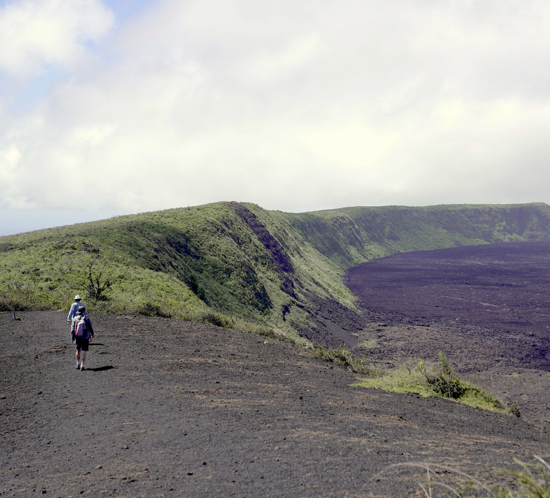 Two people walking the caldera of Sierra Negra Volcano